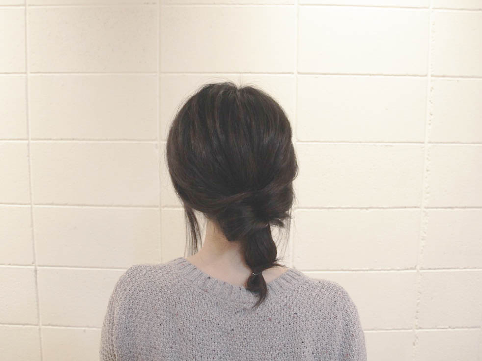 先ほど結んだ毛束を2~3回ねじり、毛先を輪っかにしてヘアゴムで結びます