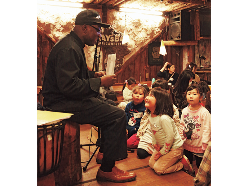 『こども寺子屋』の英語レッスン。主宰者のトニー・ジャスティスさんから「何色?」と問われる女の子。英語で答えられるかな?