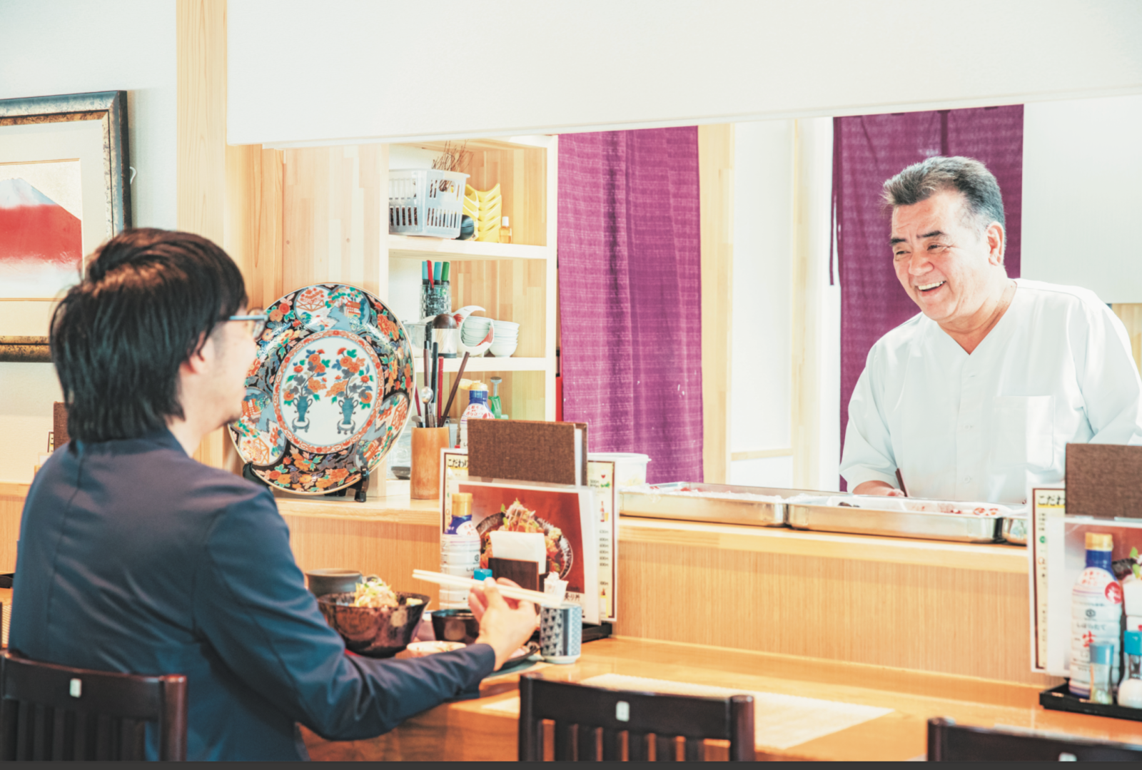 2017年に店を再建させた『志のや』の高橋さん(右)。浅野さんと談笑する。