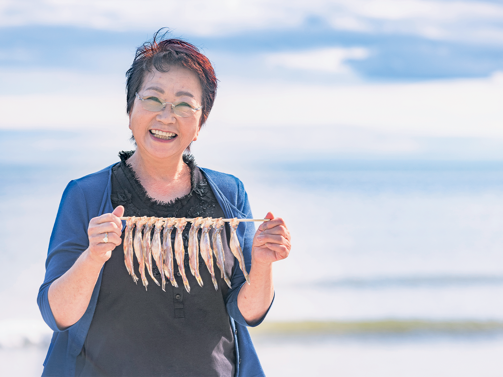 『マルダイ大森水産』代表取締役・大森照子さん。期間限定で仕入れ、オス、メス交互に串刺しされたししゃもは、卵をもってふっくらしたメスだけでなく、脂が程良くのって身が締まったオスも驚きのおいしさ。