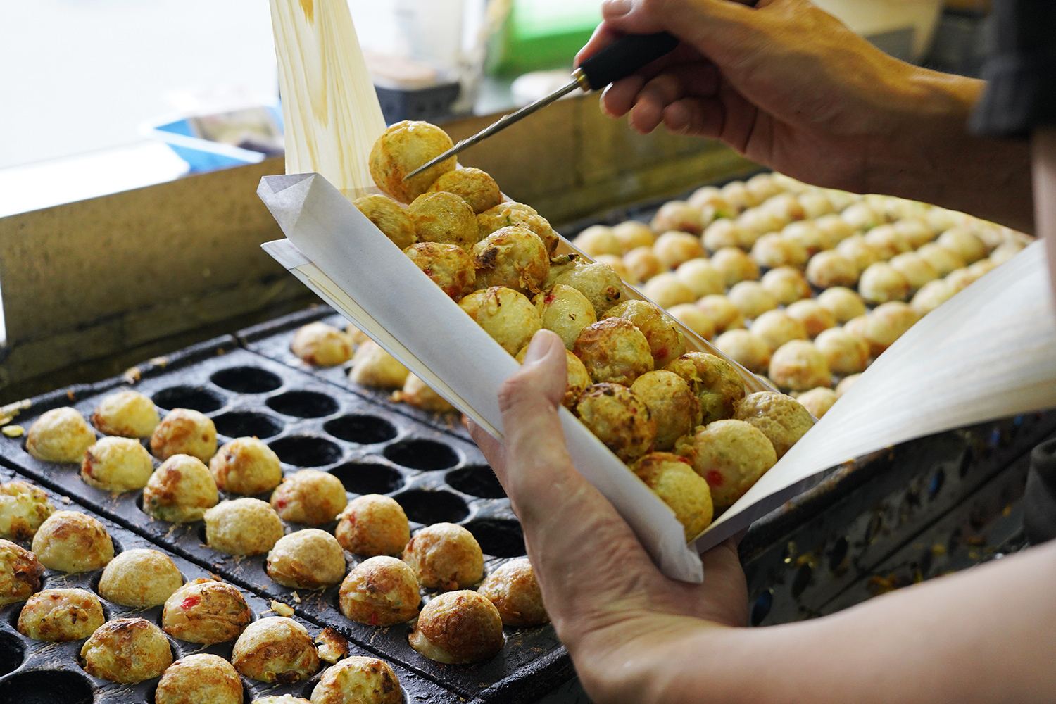 大量のたこ焼きを焼いていく