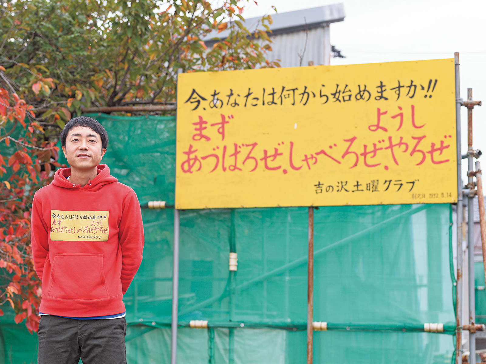 地区の情報交換の場として1983年に設立された「吉の沢土曜クラブ」の看板の前で。国道沿いに掲げられている看板で、まさに「公益DIY」の精神を象徴している。