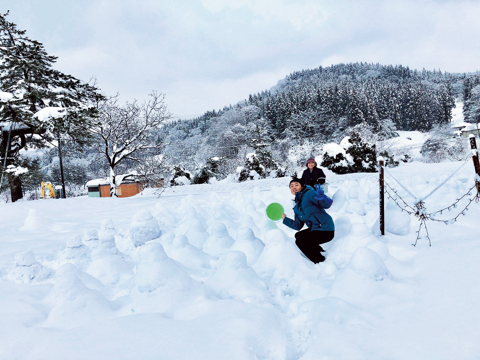 雪も楽しもう! と地元女性と108体の雪だるまづくりに挑戦。