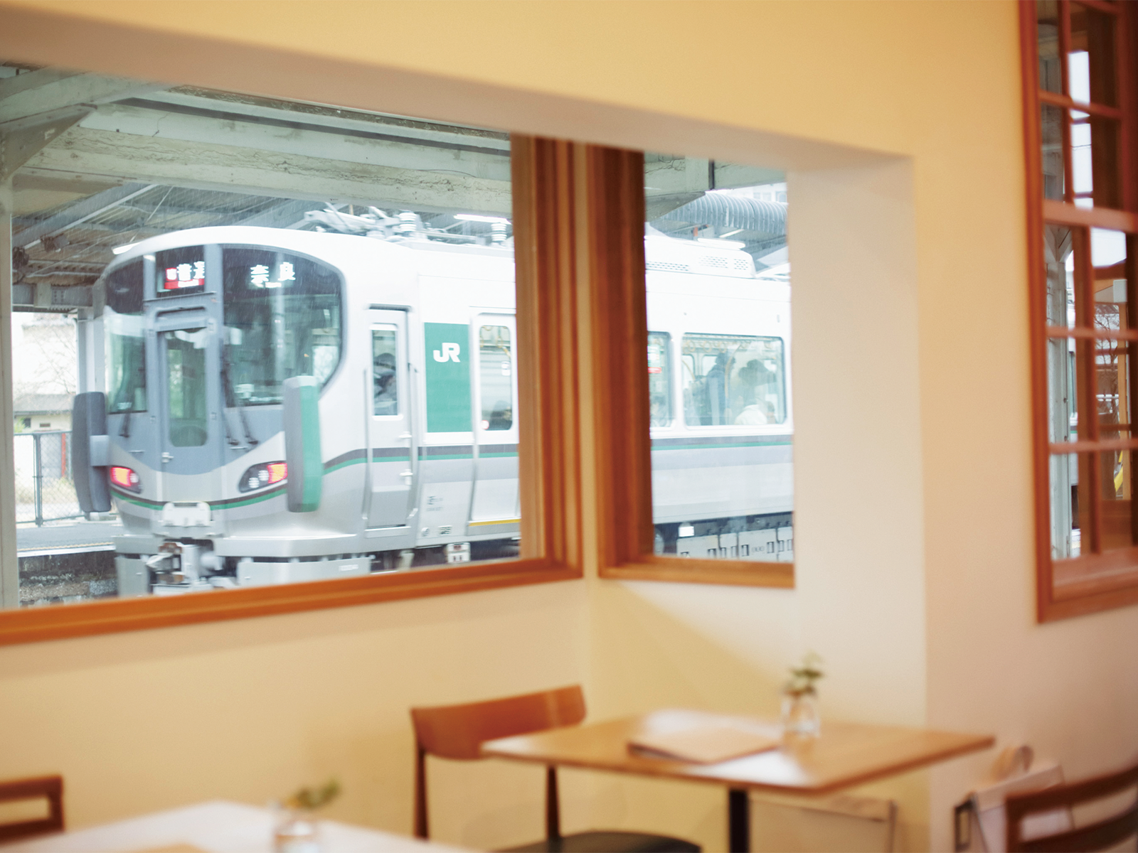京終駅のホームに面している『ハテノミドリ』の窓は、 入ってくる電車や乗降客を“額縁”のように切り取る。