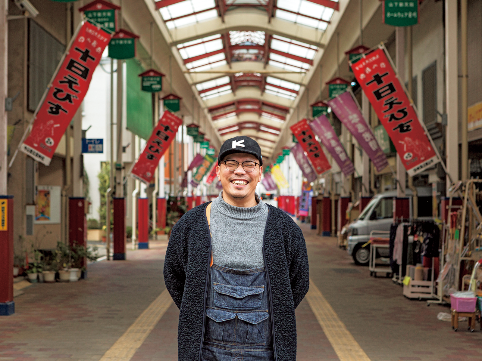 『n計画』近くの商店街に経つ甲斐さん。市外から来た人に見どころ、おもしろさを伝えながら市内を案内することも増えた。