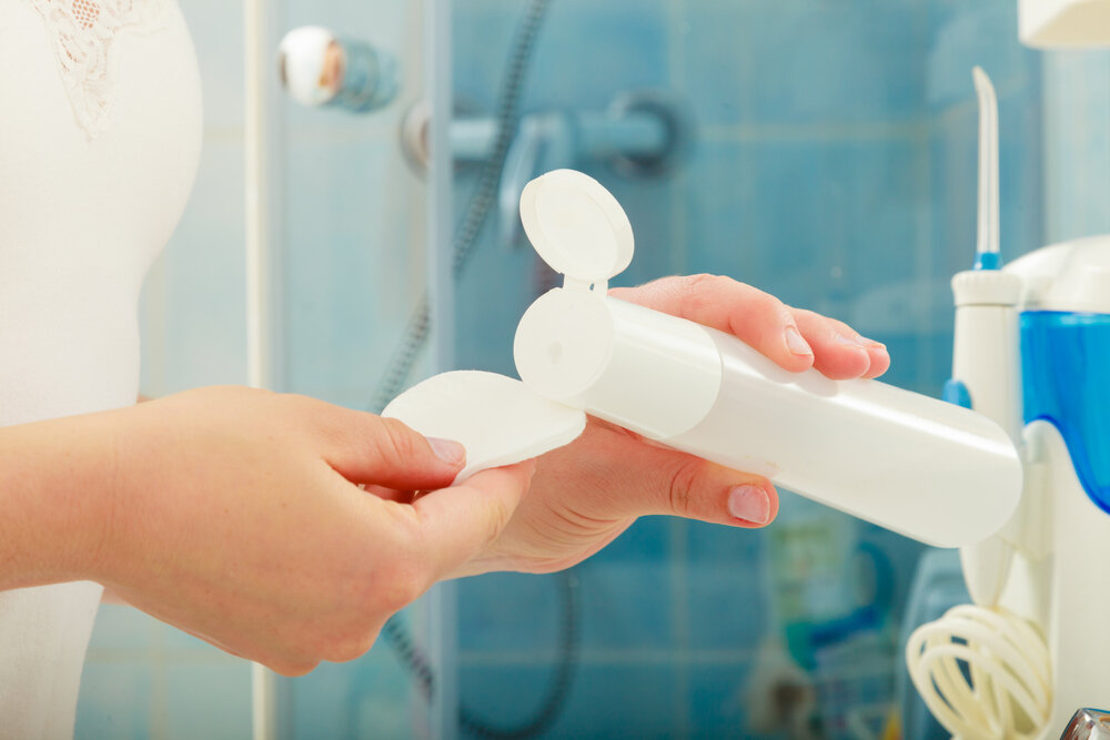 パフと化粧水を持つ女性