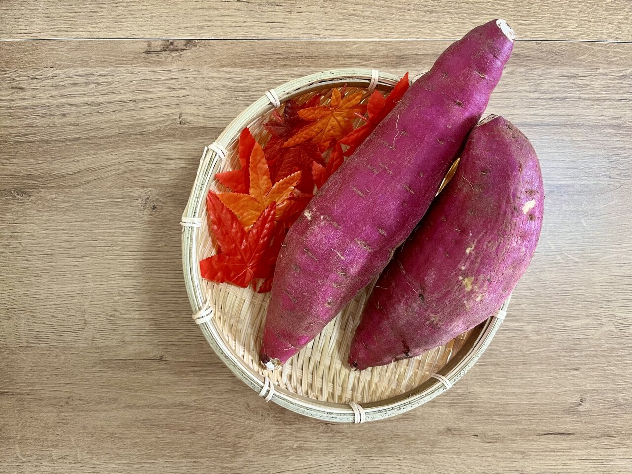 ザルに乗ったさつまいもと紅葉