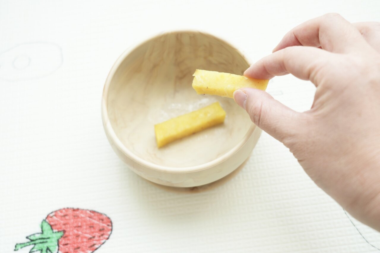 さつまいもスティックをつまむ人の手