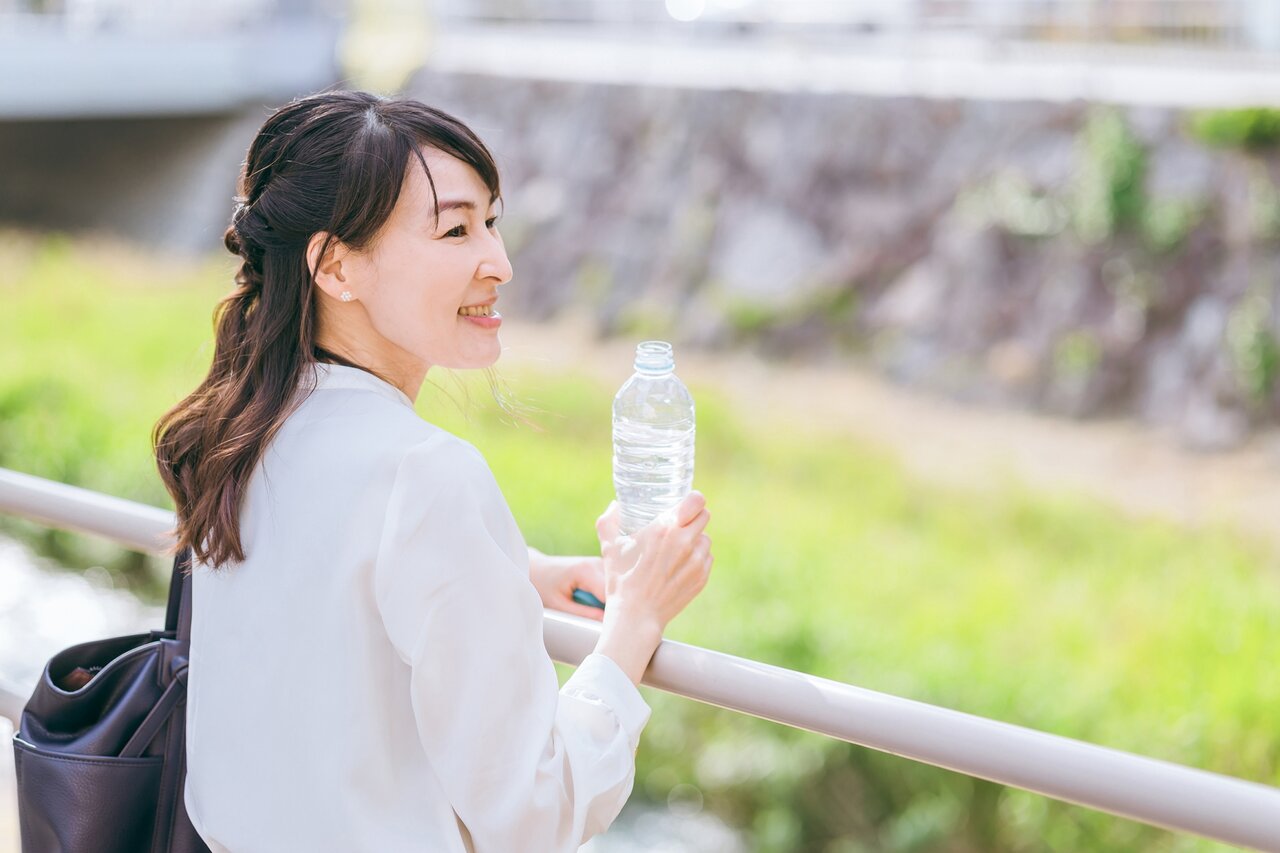 公園で水を飲むビジネスウーマン
