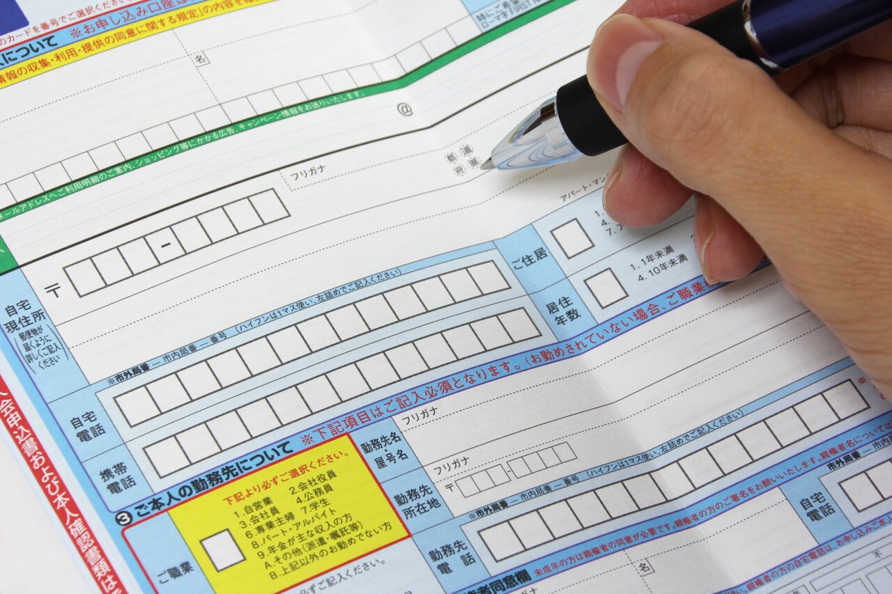 申込書に記入する人の手