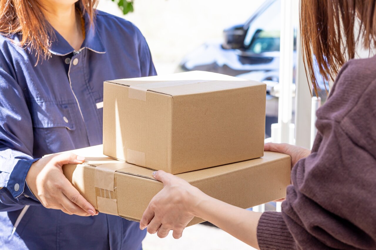 宅配便の段ボールを受け取る女性