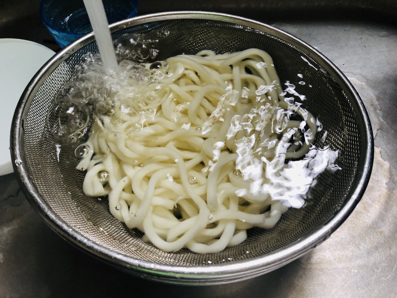 うどんを流水で洗う