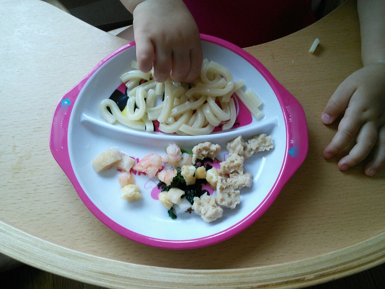 うどんを手づかみで食べる赤ちゃん
