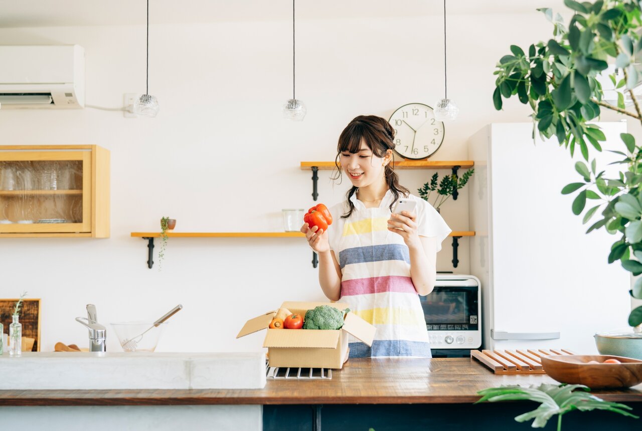 段ボールからトマトを取り出す女性