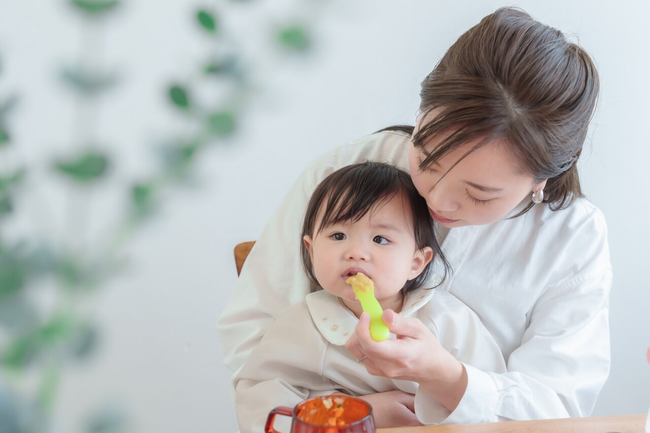 女の子に離乳食を与える女性