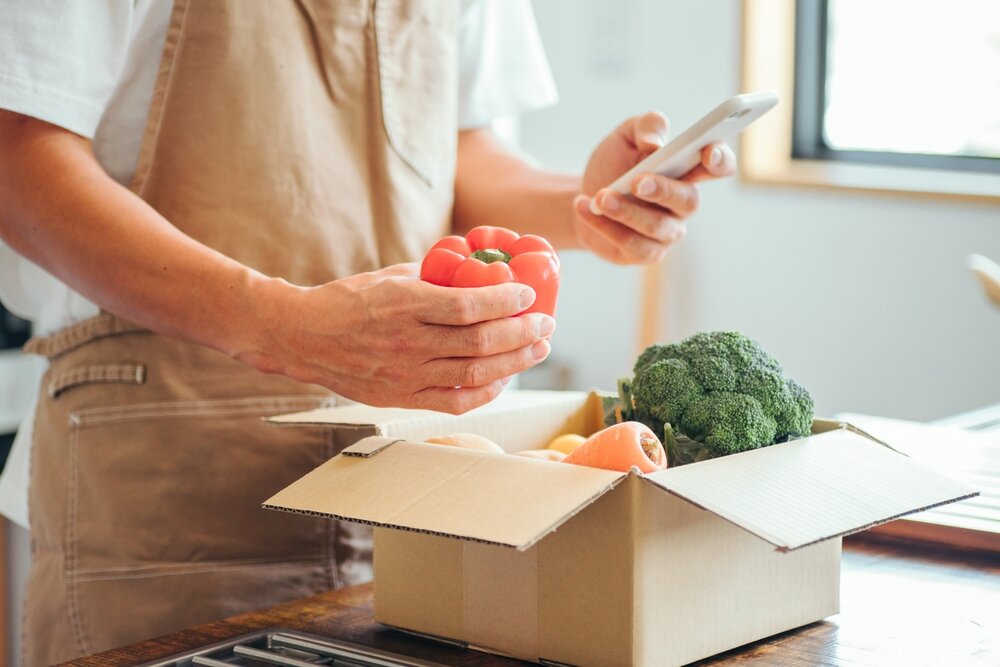 ダンボールに入った食材を確認する男性