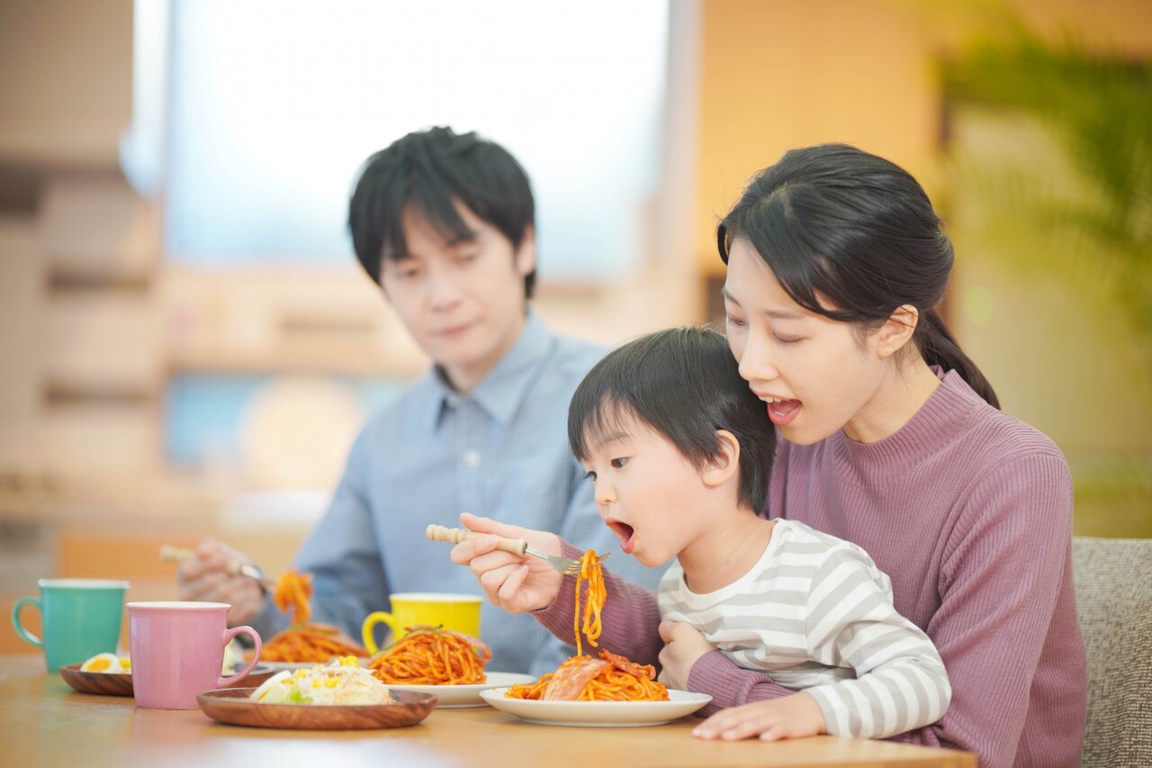 レストランでスパゲッティを食べる家族