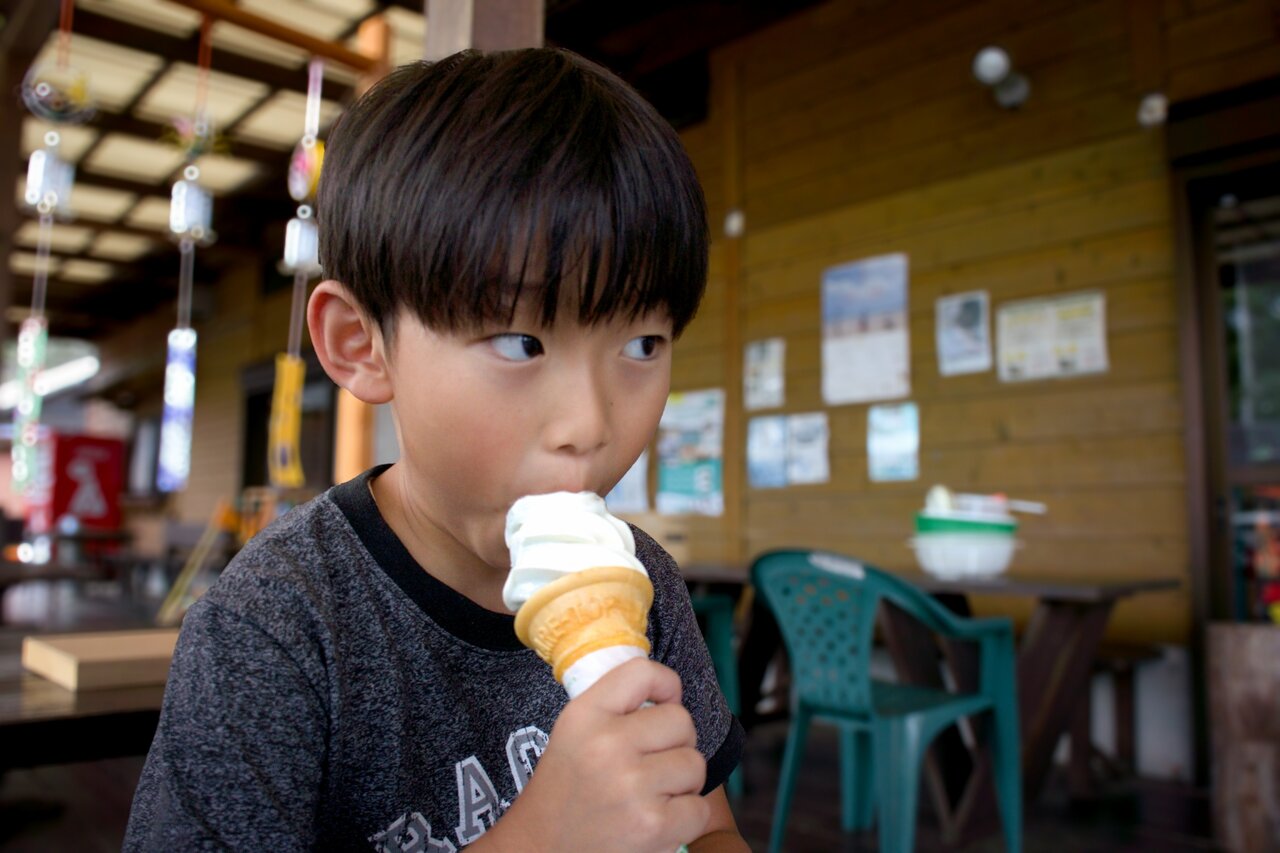 カフェでソフトクリームを食べる男の子