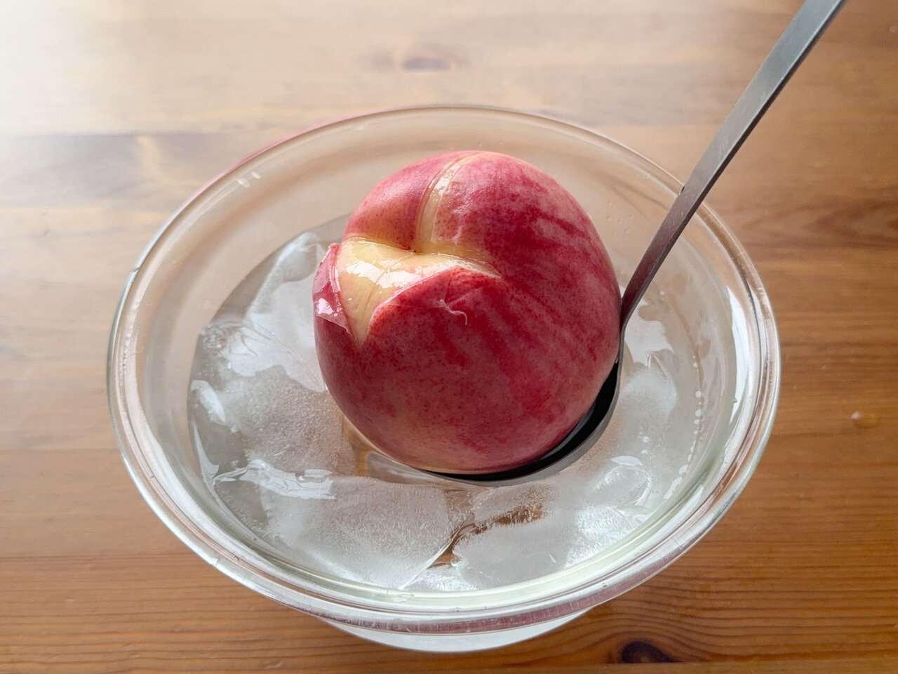 桃をお湯から取り出し、氷水の入ったボールに移す