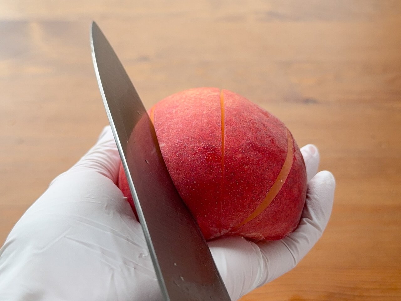 片側に残った種がある方の桃の実に3箇所包丁で切り込みを入れる