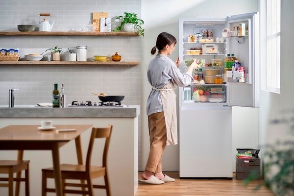 冷蔵庫を開けて中身を取り出している女性