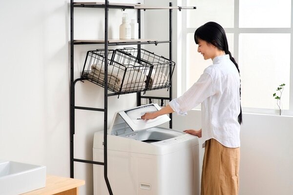 洗濯機のフタを開けている女性
