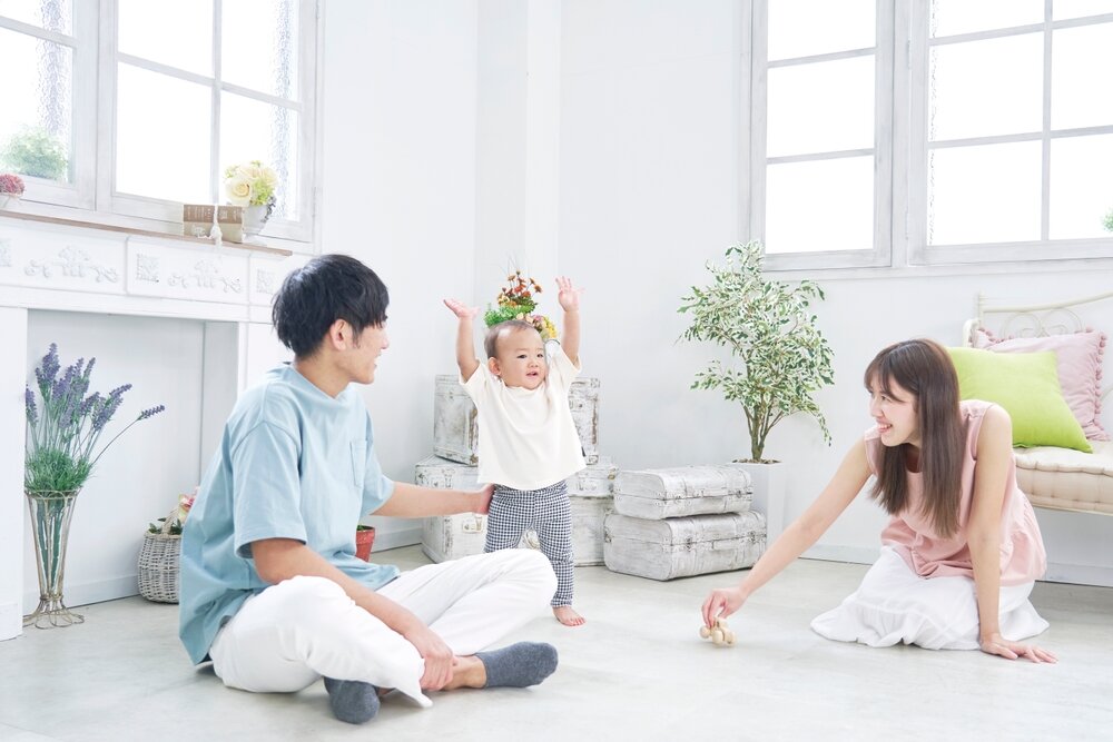 リビングで赤ちゃんと遊ぶ夫婦