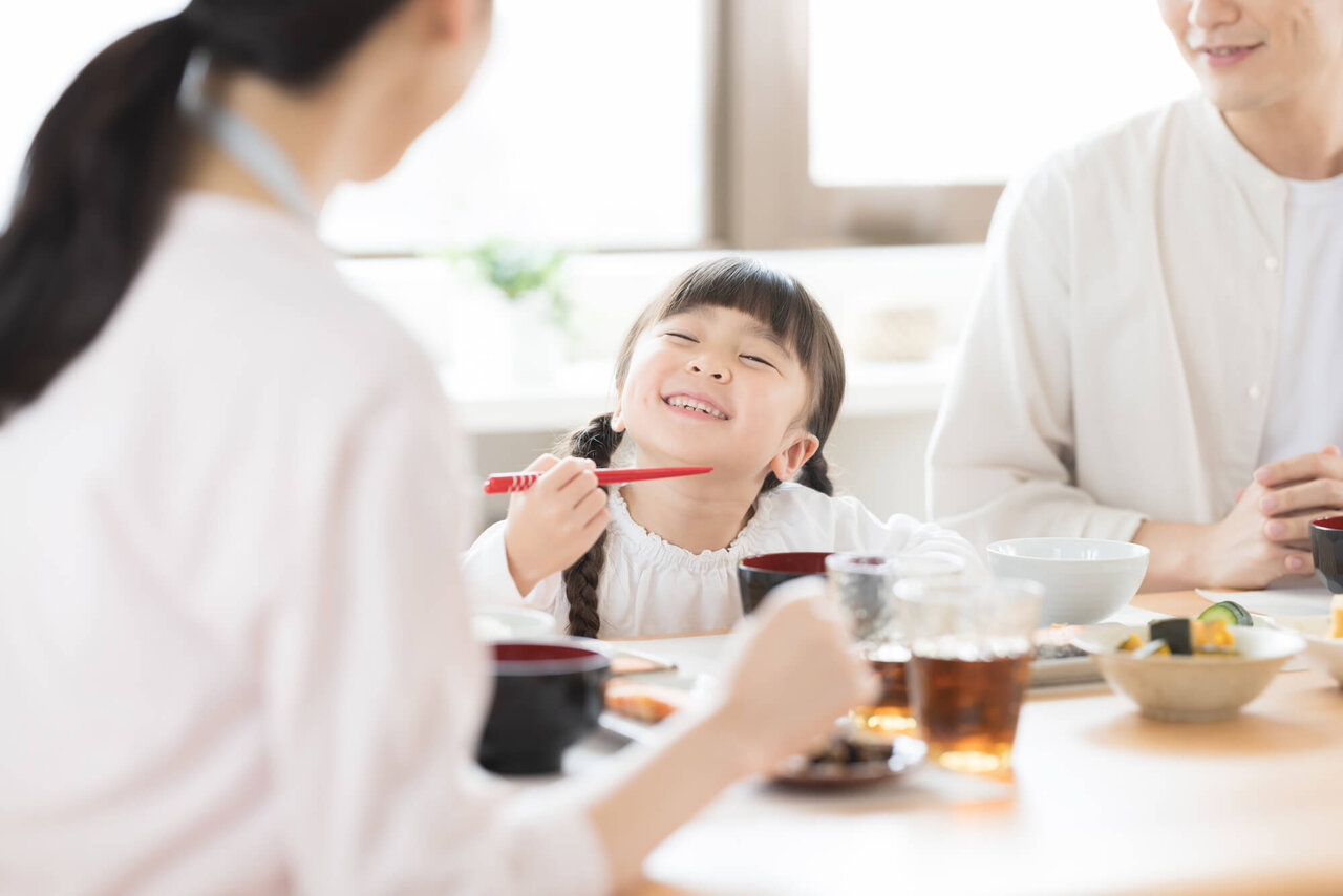 食卓で笑顔を見せる少女