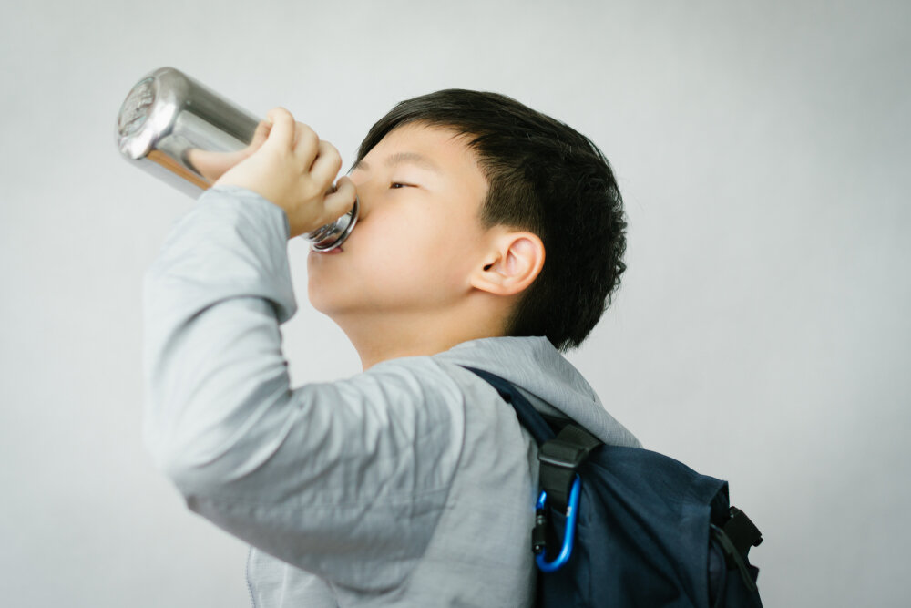 水筒で水分補給をする子ども
