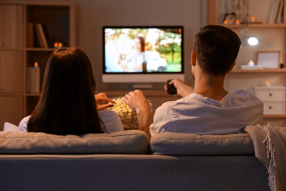 ソファに座りテレビを見る男女