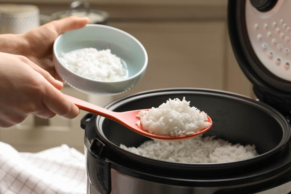 炊飯器からお茶碗にごはんをよそう人