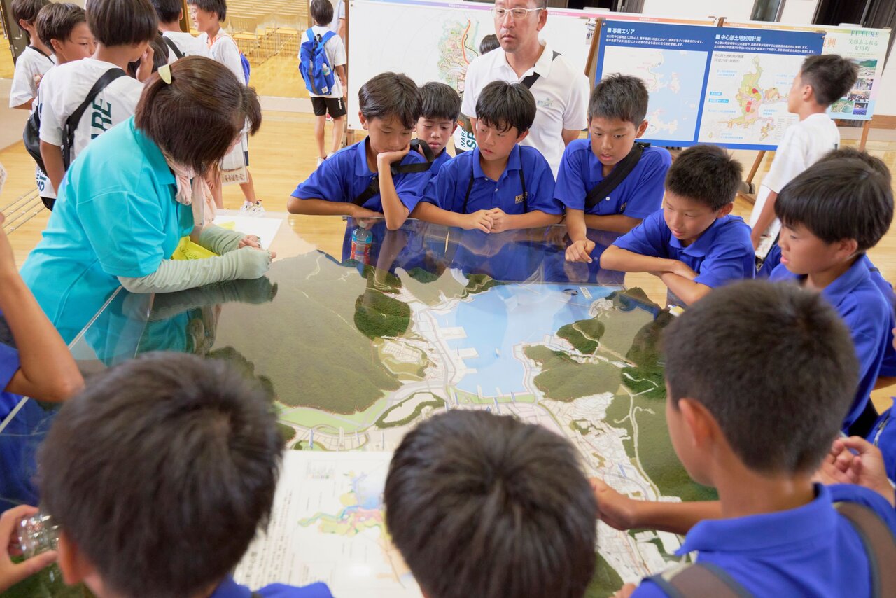 プレミアリーグU-11の「震災学習プログラム」で話を聞く子どもたち