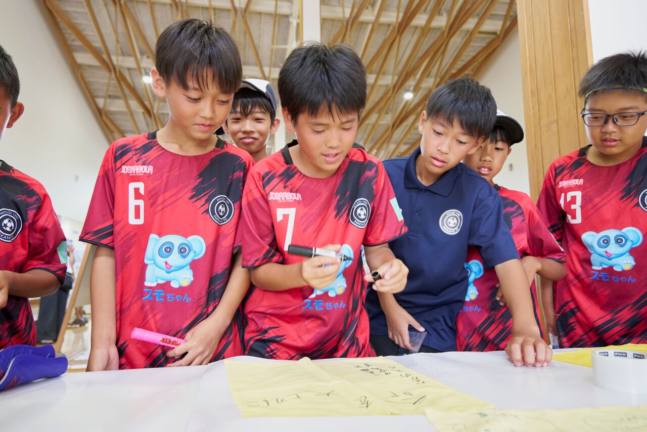 「幸せの黄色いハンカチプロジェクト」にメッセージを書き込む子どもたち