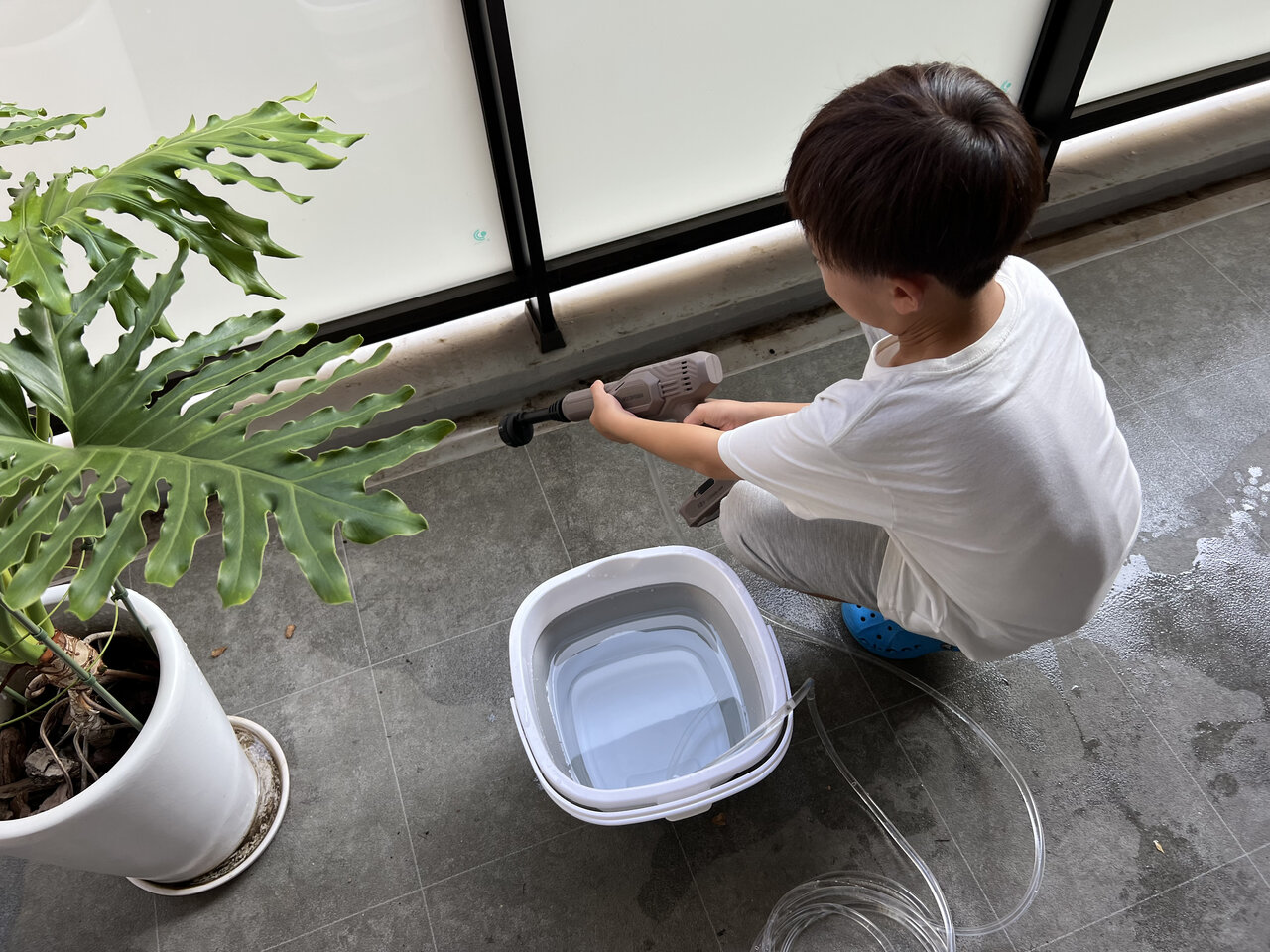 小学生の男の子がベランダを掃除している様子