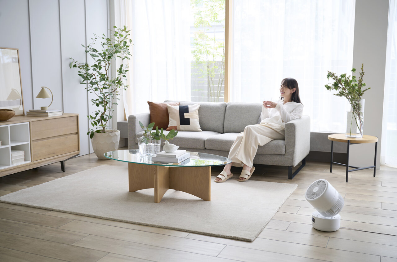 サーキュレーターのある部屋にいる女性