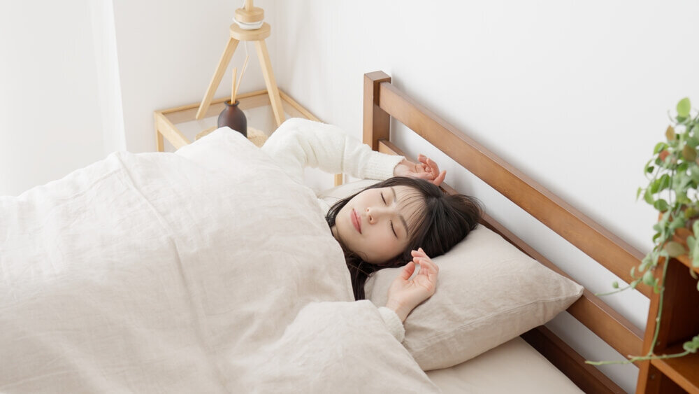 ベッドで気持ちよさそうに眠る女性