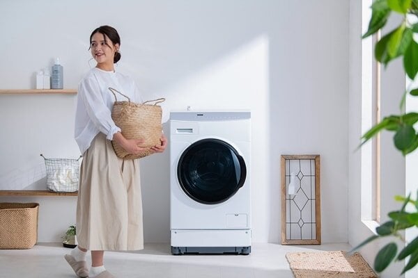 アイリスオーヤマの全自動洗乾燥濯機の前を通る女性
