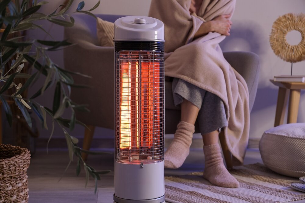 電気ヒーターで温まる人