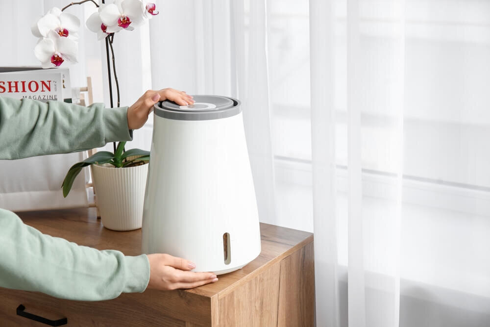 加湿器を持とうとする女性の手