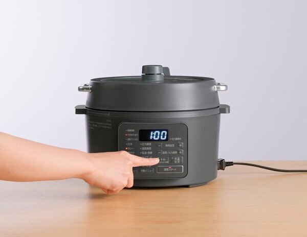 炊飯器を使用する女性