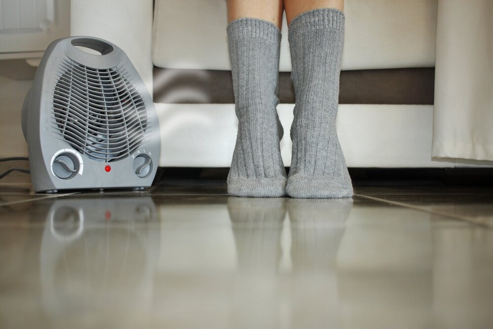 コンパクトなヒーターで足元を温める人