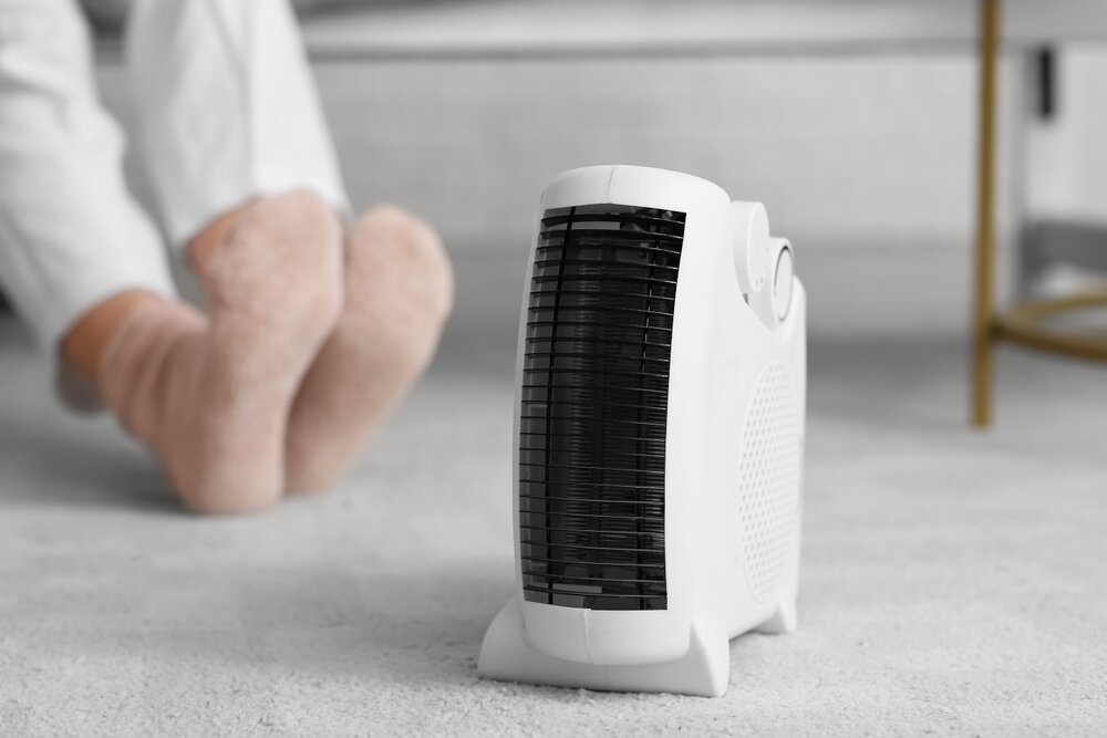 ファンヒーターで足を温める人