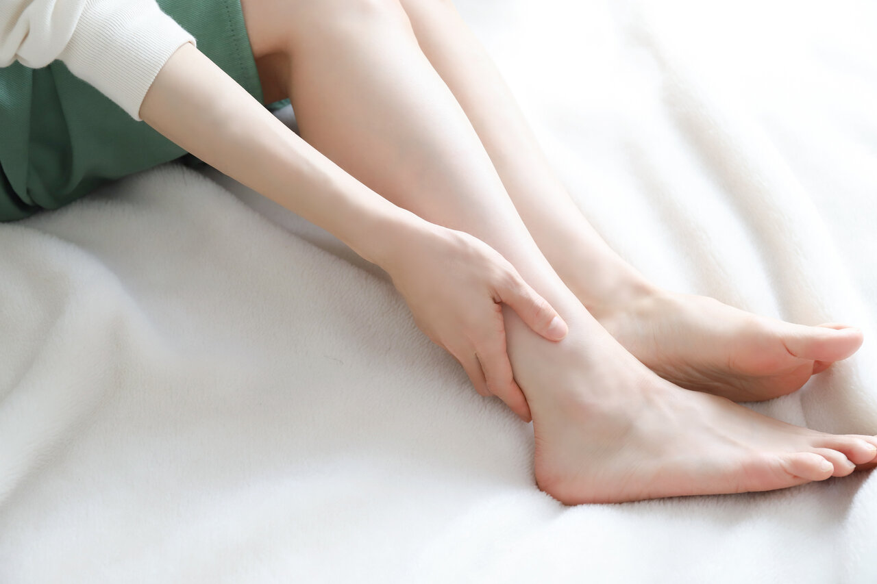 足首に触れる女性