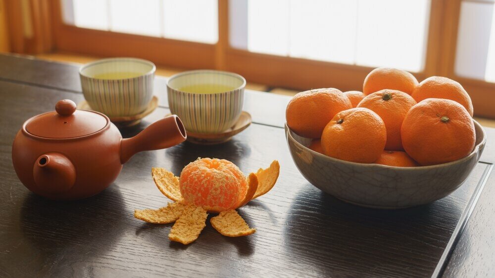 みかんと急須が置かれたこたつ