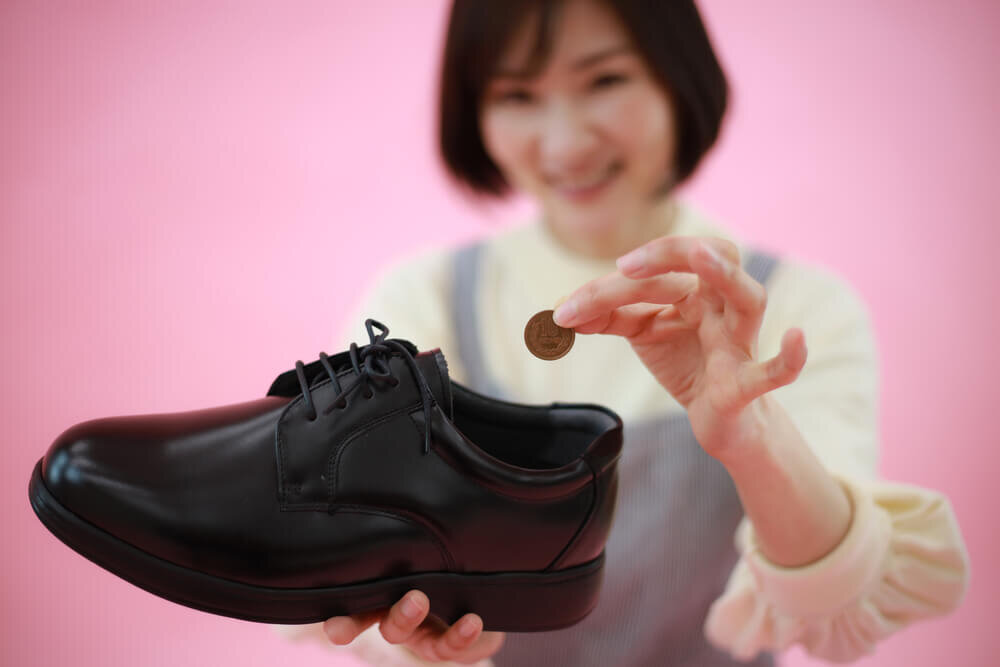 10円玉を靴に入れる女性