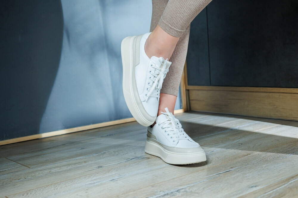白いスニーカーを履いた女性の足元