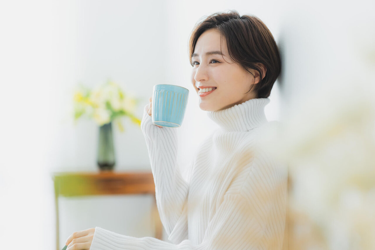 部屋で飲み物を飲む女性