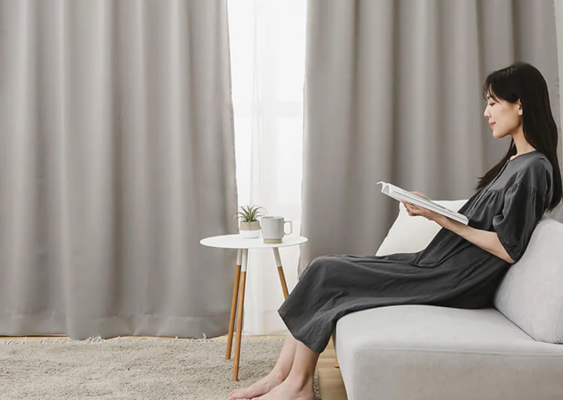 遮光カーテンの部屋でくつろぐ女性