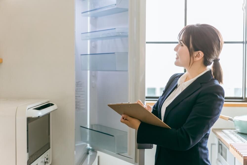 冷蔵庫をチェックする女性