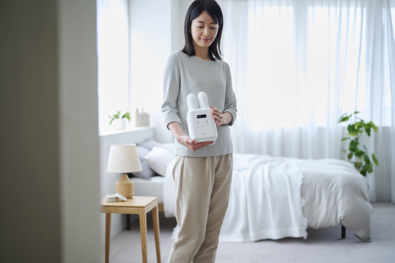 ふとん乾燥機を持つ女性